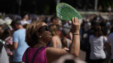 Una persona se abanica contra el calor frente al Palacio de Buckingham en Londres el 18 de julio de 2022. (Foto AP /Matt Dunham)