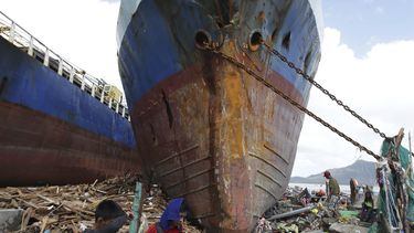 americateve | Sobrevivientes pasan cerca de un buque de gran calado que fue arrastrado a tierra por el oleaje provocado por el devastador tif&oacute;n Haiyan en la ciudad de Tacloban, capital de la provincia de Leyte, en el centro de Filipinas el domingo 10 de noviembr