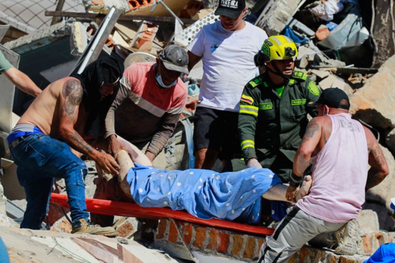 Residentes y policías transportan a un sobreviviente rescatado de entre escombros tras un terremoto, el lunes 10 de agosto de 2026, en Pereira, Colombia. (AP Foto/Miguel Ángel López)