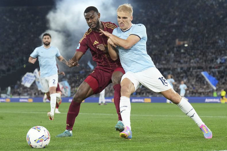 Evan Ndicka de la Roma y Gustav Isaksen de la Lazio pelean por el balón en el encuentro de la Serie A de Italia el domingo 13 de abril del 2025. (Alfredo Falcone/LaPresse via AP)