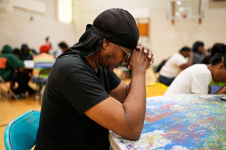 Una persona ora antes de recibir una comida gratuita en City Life Center en Gary, Indiana, el jueves 20 de agosto de 2026, más de una semana después del paso de una fuerte tormenta en el área. (AP Foto/Nam Y. Huh)