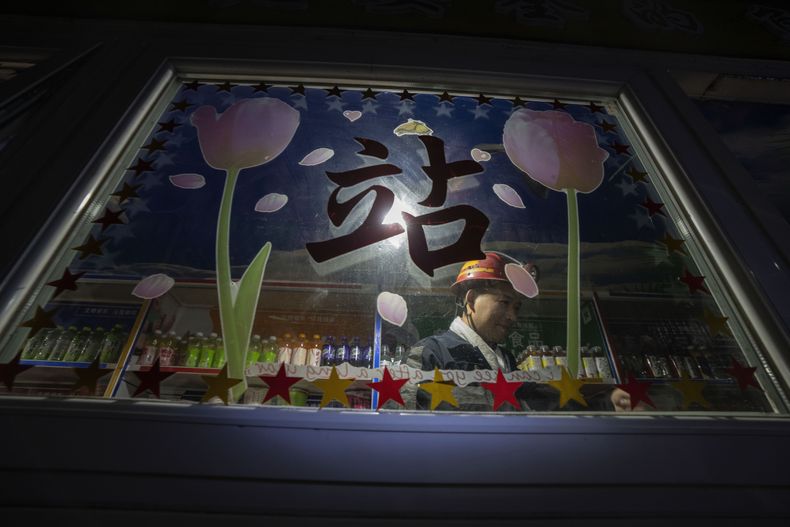 Un minero de pie tras una ventana en una tienda de alimentación subterránea en la mina de carbón de Hongliulin, cerca de la ciudad de Shenmu, en la provincia de Shaanxi, en el noroeste de China,e el martes 25 de abril de 2023. Ante las sanciones estadounidenses, Huawei Technologies Ltd. ha entrado en otros sectores como vehículos autónomos, fábricas y minas. (AP Foto/Ng Han Guan)