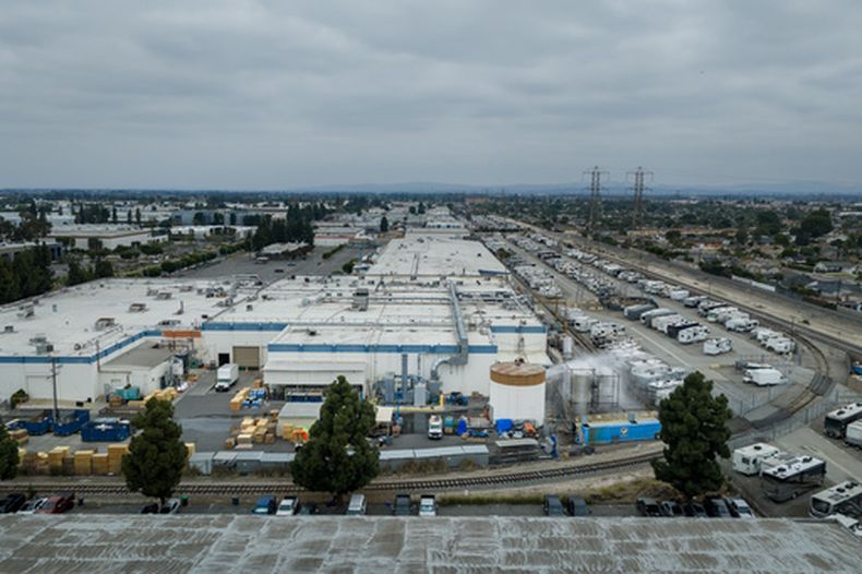 Camiones cisterna rocían agua sobre un contenedor dañado en GKN Aerospace, el domingo 24 de mayo de 2026, en Garden Grove, California, después de que el contenedor químico utilizado en la fabricación de partes de plástico se sobrecalentó el jueves. (AP Foto/Ethan Swope)