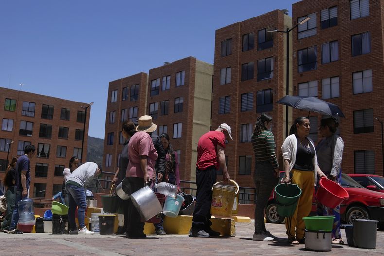 ARCHIVO - Residentes hacen fila para recoger agua de un camión durante el racionamiento de agua en La Calera, en las afueras de Bogotá, Colombia, el 16 de abril de 2024. (AP Foto/Fernando Vergara, Archivo)