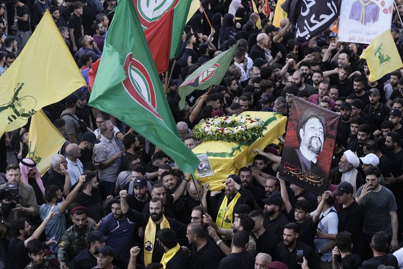 ARCHIVO - Combatientes de Hezbollah llevan uno de los ataúdes de cuatro compañeros caídos que murieron el martes después de que sus localizadores portátiles explotaran, durante su procesión fúnebre en el suburbio sur de Beirut, Líbano, miércoles 18 de septiembre de 2024. (AP foto/Bilal Hussein, archivo)