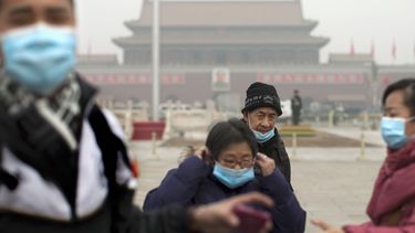 americateve | Turistas se colocan m&aacute;scaras luego de posar para tomarse fotograf&iacute;as en la plaza Tiananmen en un d&iacute;a donde hubo gran contaminaci&oacute;n en Beijing el martes 25 de febrero de 2014.  (Foto de AP/Alexander F. Yuan)