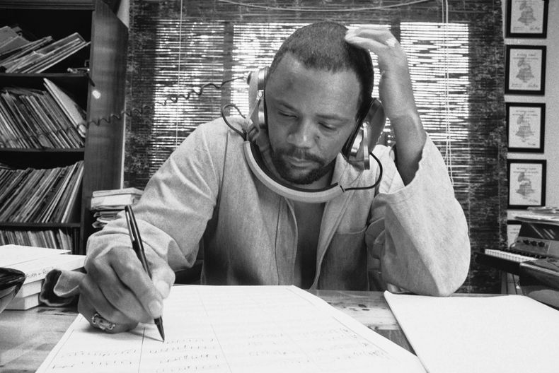 ARCHIVO - El compositor Quincy Jones en el estudio de su casa en octubre de 1974 escribiendo música y escuchando una grabación con sus auriculares. (Foto AP/George Brich, archivo)