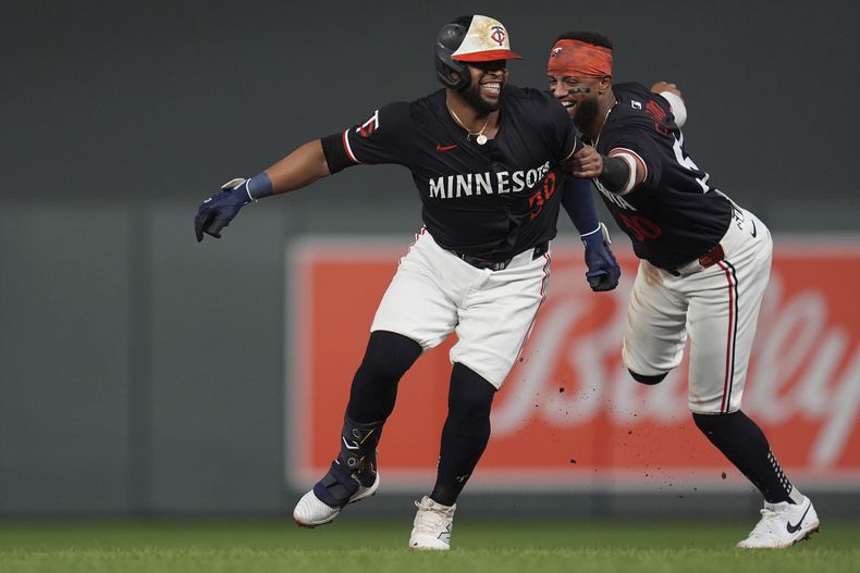 El dominicano Carlos Santana y el boricua Willi Castro, de los Mellizos de Minnesota, festejan después de que el primero remolcó la carrera del triunfo ante los Rays de Tampa Bay, el martes 18 de junio de 2024 (AP Foto/Abbie Parr)