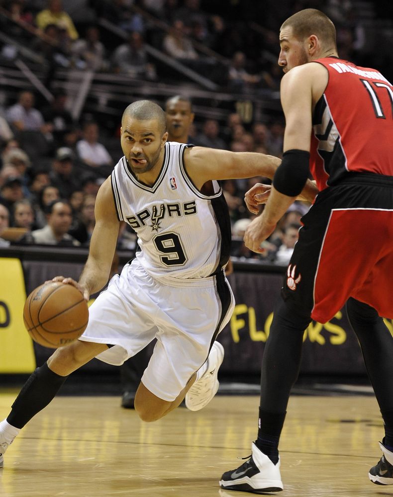 El jugador franc&eacute;s Tony Parker, de los Spurs de San Antonio, ataca la defensa montada por el lituano Jonas Valanciunas, de los Raptors de Toronto, en la primera mitad del juego del lunes 23 de diciembre de 2013, en San Antonio. (Foto AP/Darren Abat