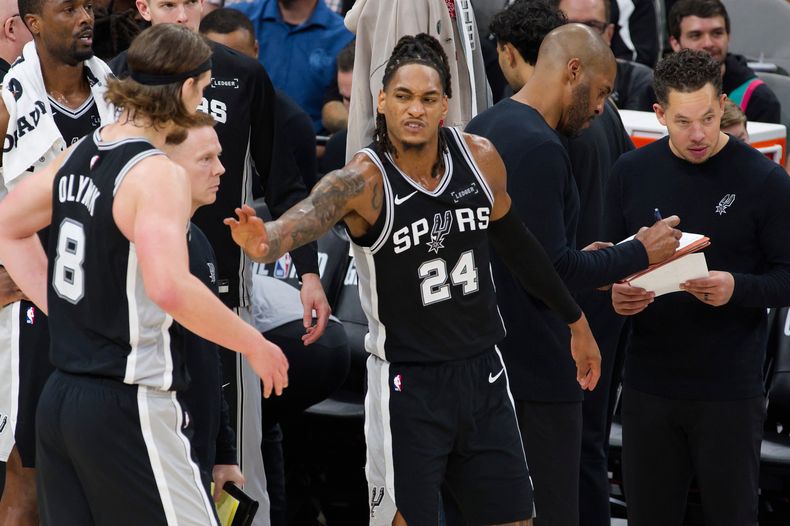 Devin Vassell (24), base de los Spurs de San Antonio, celebra un enceste con su compañero Kelly Olynyk, durante el encuentro del martes 18 de noviembre de 2025 (AP Foto/Darren Abate)