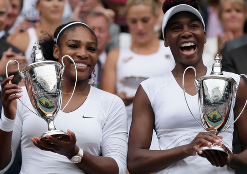 ARCHIVO - Foto del 9 de julio del 2016, Serena y Venus Williams sostienen sus trofeos como campeonas del Wimbledon tras vencer en la final a la kazaja Yaroslava Shvedova y la húngara Timea Babos. (AP Foto/Tim Ireland, Archivo)