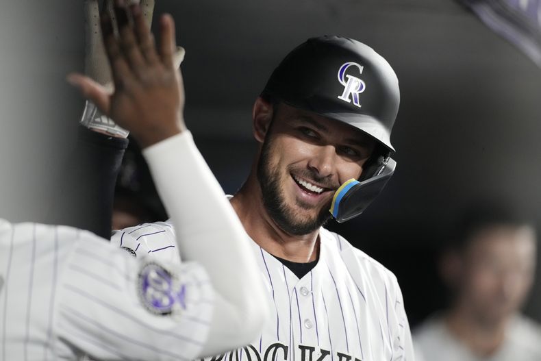 Kris Bryant de los Rockies de Colorado es felicitado en el dugout tras pegar un jonrón frente al relevista de los Cachorros de Chicago Daniel Palencia en el encuentro del martes 12 de septiembre del 2023. (AP Foto/David Zalubowski)