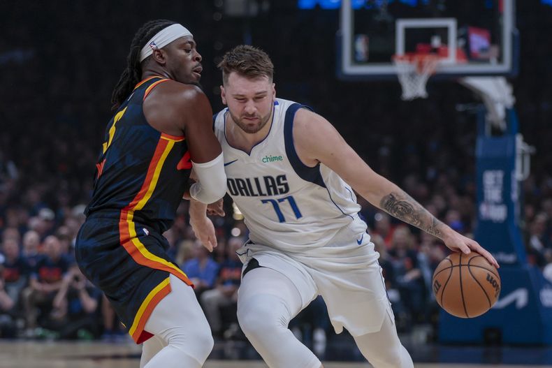 El base de los Mavericks de Dallas Luka Doncic avanza con el balón hacia la canasta superando al base del Thunder de Oklahoma City Luguentz Dort en el juego 5 de las semifinales de la Conferencia Oeste el miércoles 15 de mayo del 2024. (AP Foto/Nate Billings)