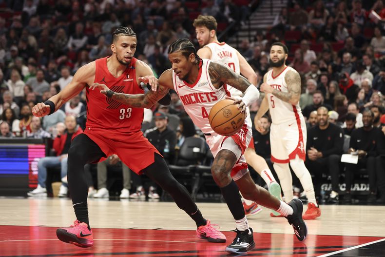 El escolta de los Rockets de Houston, Jalen Green (4), conduce por la cancha mientras el alero de los Trail Blazers de Portland, Toumani Camara (33), defiende durante la primera mitad de un partido de baloncesto de la NBA, el sábado 18 de enero de 2025, en Portland, Oregón (AP Foto/Amanda Loman)
