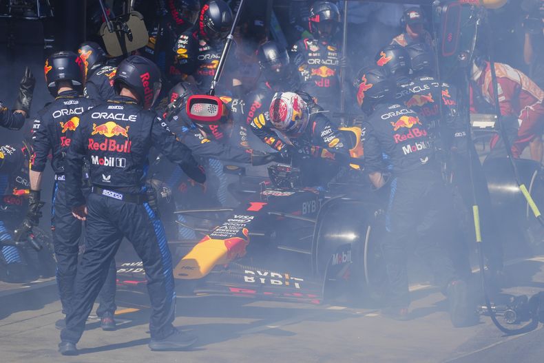Mecánicos trabajar para apagar las llamas del monoplaza del piloto holandés Max Verstappen en la cuarta vuelta del Gran Premio de Australia el domingo 24 de marzo del 2024. (AP Foto/Scott Barbour,Pool)