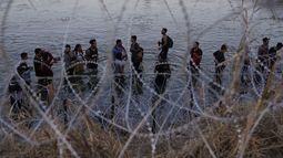 ARCHIVO - Migrantes esperan después de cruzar el río Bravo y entrar en Estados Unidos, el 23 de septiembre de 2023, en Eagle Pass, Texas. (AP Foto/Eric Gay, Archivo)