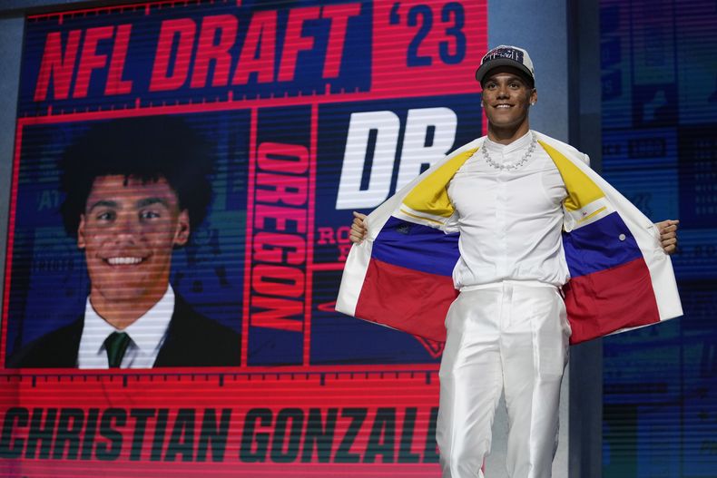 El cornerback Christian Gonzalez parado en el escenario muestra los colores de la bandera de Colombia en su traje tras convertirse en la 17ma selección por parte de los Patriots de Nueva Inglaterra durante el primer día del draft el jueves 27 de abril del 2023. (AP Foto/Jeff Roberson)