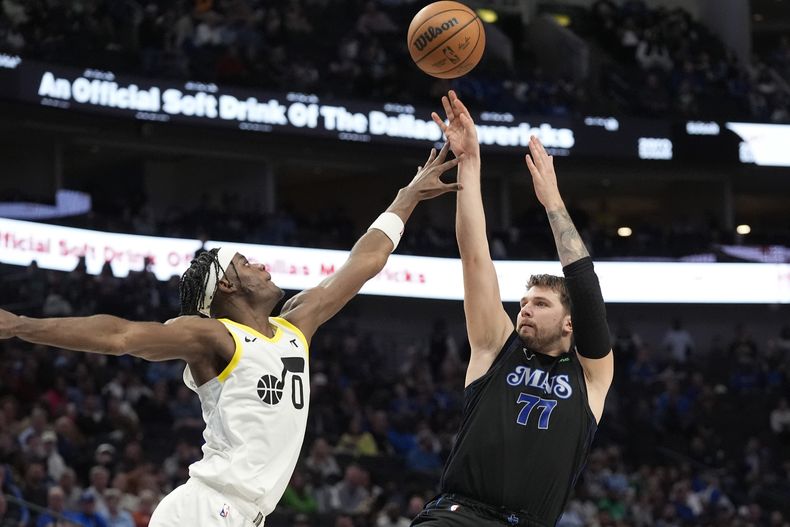 El base de los Mavericks de Dallas Luka Doncic lanza el balón sobre el alero del Jazz de Utah Taylor Hendricks en el encuentro de la NBA del jueves 21 de marzo del 2024. (AP Foto/LM Otero)