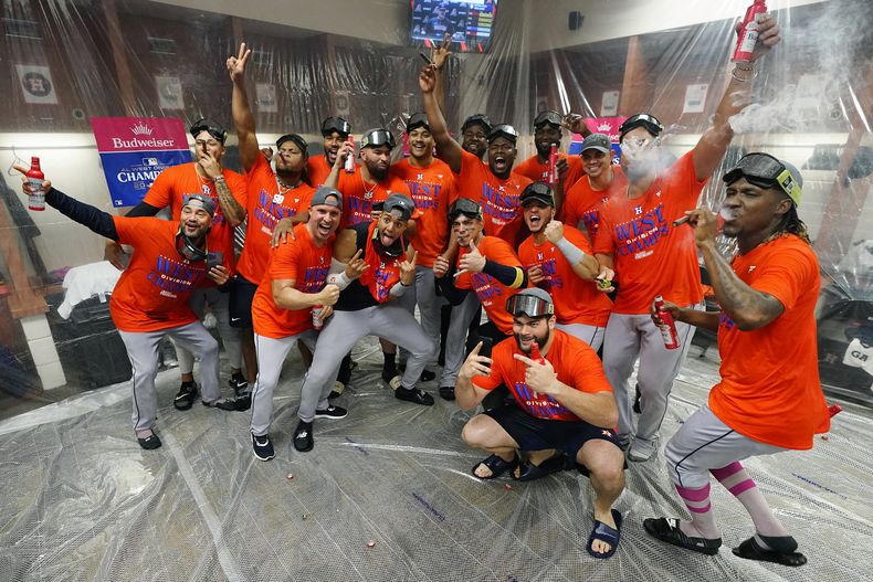 Los jugadores de los Astros de Houston celebran en el camerino luego de ganar el banderín de la división Oeste de la Liga Americana, tras el juego ante los Diamondbacks de Arizona, en Phoenix. Domingo 1 de octubre de 2023. (AP Foto/Ross D. Franklin)