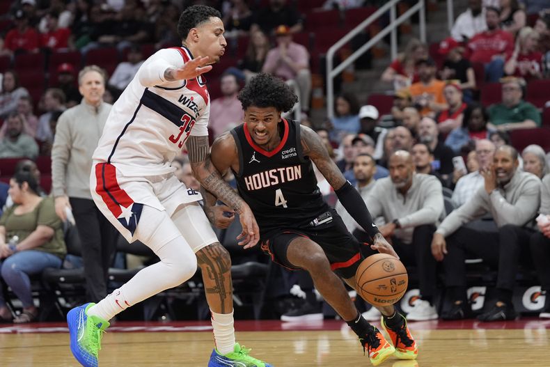 Jalen Green de los Rockets de Houston avanza hacia la canasta con el balón mientras lo defiende Kyle Kuzma de los Wizards de Washington en el encuentro del jueves 14 de marzo del 2024. (AP Foto/David J. Phillip)