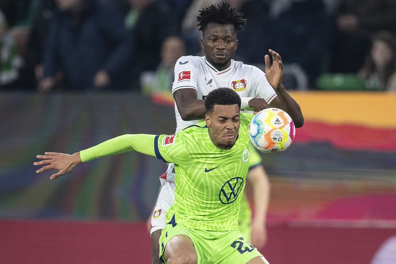 ARCHIVO - Felix Nmecha, del Wolfsburgo, intenta controlar un balón delante de Edmond Tapsoba, del Leverkusen, durante un partido de la liga alemana, el 16 de abril de 2023 (Swen Pfoertner/dpa via AP, archivo)
