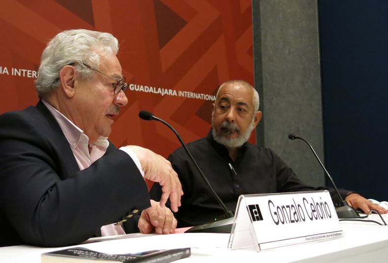ARCHIVO - El escritor mexicano Gonzalo Celorio, a la izquierda, habla durante una mesa redonda sobre la obra del escritor cubano Leonardo Padura, a la derecha, en la Feria Internacional del Libro de Guadalajara, México, el viernes 4 de diciembre de 2015. (Foto AP/Berenice Bautista, archivo)