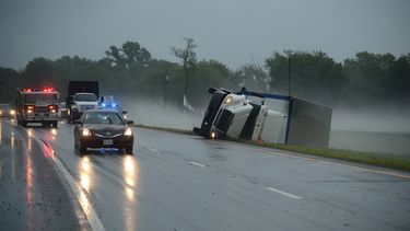 americateve | Veh&iacute;culos de rescate pasan junto a un cami&oacute;n de carga volcado a consecuencia de de los vientos provocados por una tormenta en Cheriton, Virginia, que caus&oacute; dos muertes el jueves 24 de julio de 2014. (Foto de AP/Eastern Shore News, Jay