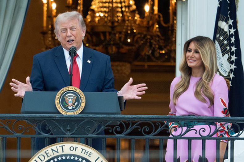 El presidente de Estados Unidos, Donald Trump, y la primera dama, Melania Trump, se dirigen a los asistentes desde el balcón de la Sala Azul de la Casa Blanca durante el picnic anual del Congreso en el Jardín Sur, el martes 19 de mayo de 2026 en Washington. (AP Foto/Manuel Balce Ceneta)