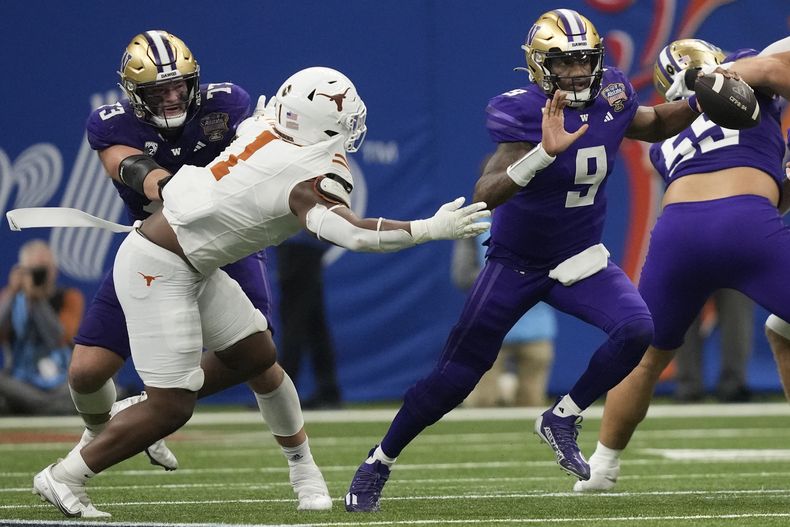 Michael Penix Jr. (9), quarterback de Washington, escapa de la presión con el balón, mientras el defensive end Justice Finkley (1), de Texas, busca alcanzarlo durante la primera mitad del Sugar Bowl, en la semifinal de temporada del fútbol americano de la NCAA, el lunes 1 de enero de 2024, en Nueva Orleans. (AP Foto/Gerald Herbert)