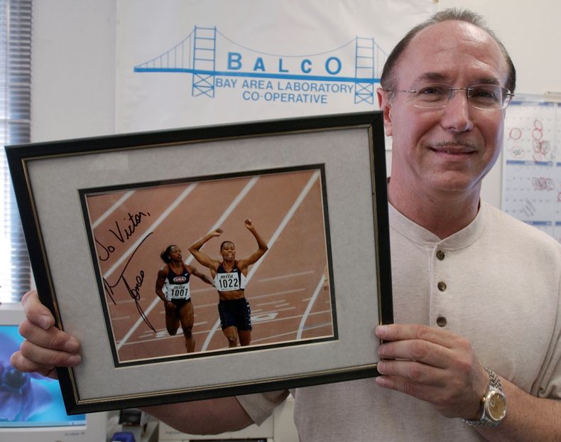 ARCHIVO - Victor Conte, fundador del labotatorio BALCO sostiene una fotografía autografiada dedicada a él de la estrella de atletismo Marion Jones en su oficina en Burlingame, California, el 31 de octubre de 2003. (AP Foto/Paul Sakuma, Archivo)