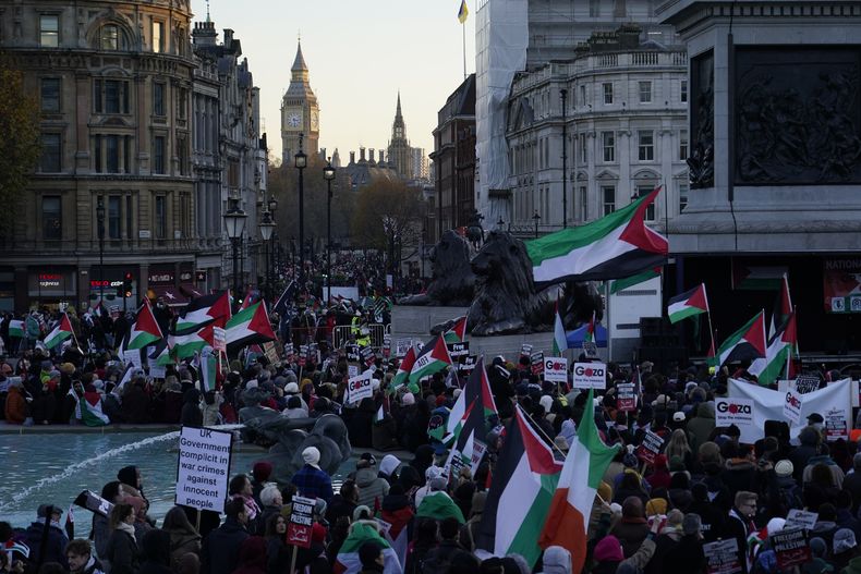 Manifestantes sostienen banderas y pancartas durante una protesta a favor de los palestinos en la Plaza de Trafalgar de Londres, el sábado 25 de noviembre de 2023. (AP Foto/Alberto Pezzali)