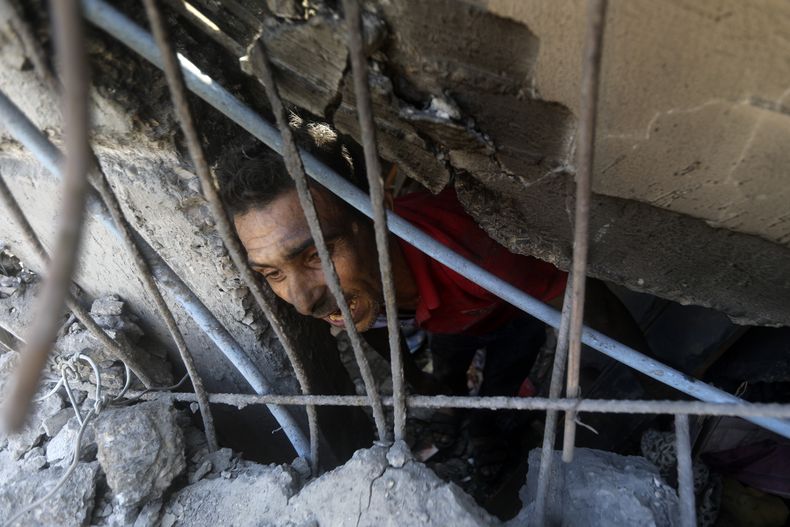 Palestinos buscan sobrevivientes entre los escombros de un edificio impactado por un bombardeo israelí en el campamento de refugiados de Jan Yunis, el lunes de noviembre de 2023, en el sur de la Franja de Gaza. (AP Foto/Mohammed Dahman)