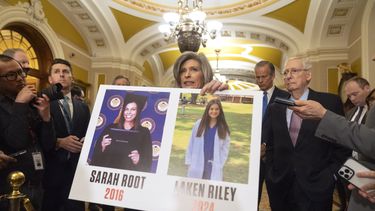 ARCHIVO - La senadora Joni Ernst, representante de Iowa, sostiene un cartel con fotos de las víctimas de asesinato Sarah Root y Laken Riley mientras habla en el Capitolio, el 27 de febrero de 2024, en Washington. (AP Foto/Mark Schiefelbein, Archivo)
