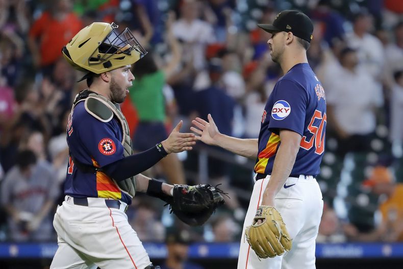 El receptor de los Astros de Houston, Víctor Caratini, a la izquierda, y el lanzador de cierre, Tayler Scott, a la derecha, celebran su victoria sobre los Cerveceros de Milwaukee después de un partido de béisbol, el domingo 19 de mayo de 2024, en Houston. (AP Foto/Michael Wyke)