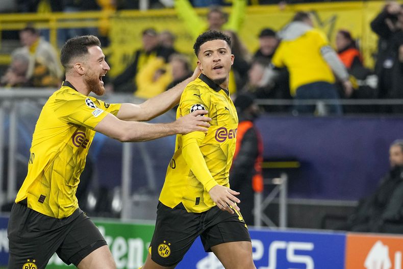 Jadon Sancho (derecha) celebra con Salih Ozcan del Borussia Dortmund tras anotar el primer gol ante PSV Eindhoven en la vuelta de los octavos de final de la Liga de Campeones, el miércoles 13 de marzo de 2024. (AP Foto/Martin Meissner)