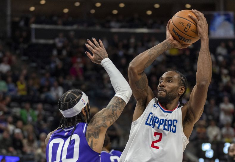 Kawhi Leonard (2), de los Clippers de Los Ángeles, dispara sobre la marca defensiva de Jordan Clarkson (00), del Jazz de Utah, durante la segunda mitad del juego de baloncesto de la NBA, el viernes 8 de diciembre de 2023, en Salt Lake City. (AP Photo/Rick Egan)