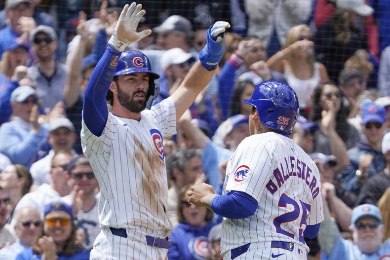 Dansby Swanson, izquierda, y Moisés Ballesteros (25), de los Cachorros de Chicago, celebran después de anotar contra los Medias Blancas de Chicago durante la segunda entrada de un juego de béisbol el sábado 17 de mayo de 2025, en Chicago. (AP Foto/David Banks)