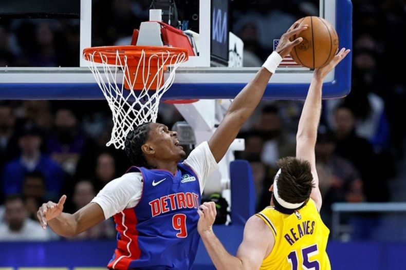 Ausar Thompson (9), de los Pistons de Detroit, bloquea un tiro de Austin Reaves (15), de los Lakers de Los Ángeles, durante la primera mitad del juego de baloncesto de la NBA el lunes 23 de marzo de 2026, en Detroit. (AP Foto/Duane Burleson)