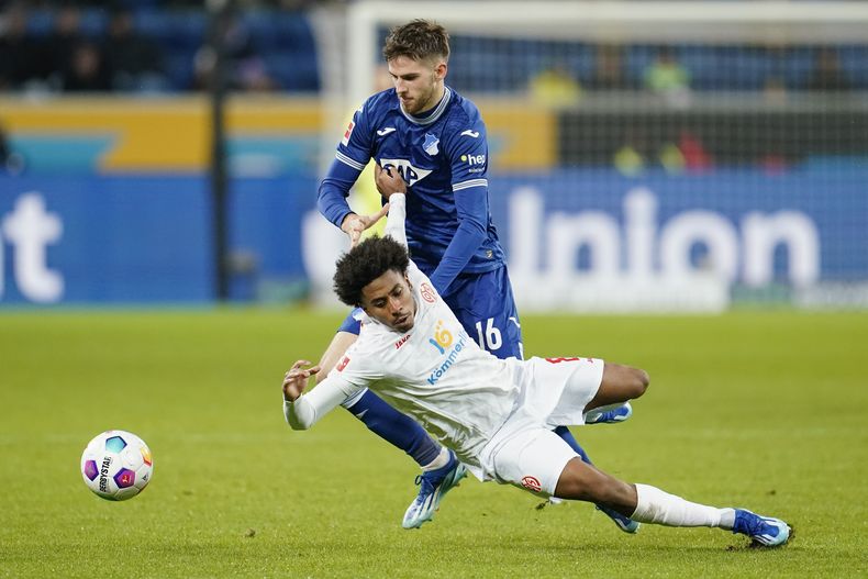 Anton Stach del Hoffenheim (detrás) y Leandro Barreiro del Mainz (adelante) disputan el balón durante el partido de la Liga Alemana en Sinsheim, Alemania, el domingo 26 de noviembre de 2023. (Uwe Anspach/dpa via AP)