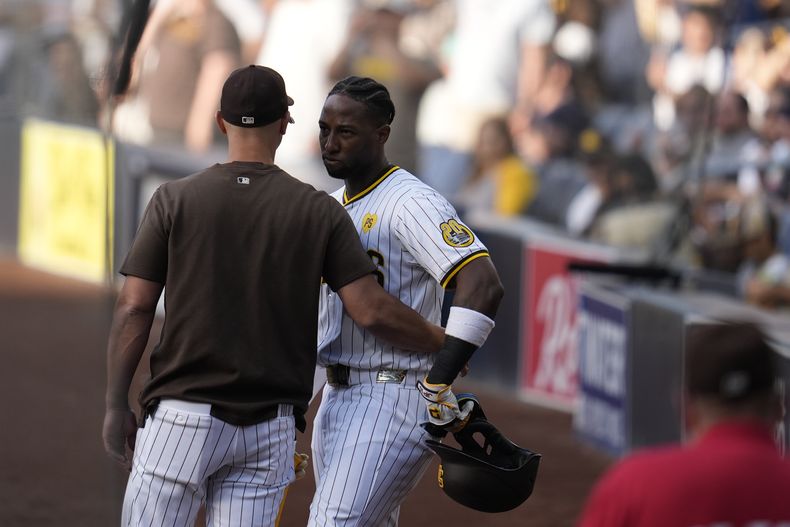 Jurickson Profar, de los Padres de San Diego, es controlado durante un conato de riña en el juego ante los Nacionales de Washington, el martes 25 de junio de 2024 (AP Foto/Gregory Bull)