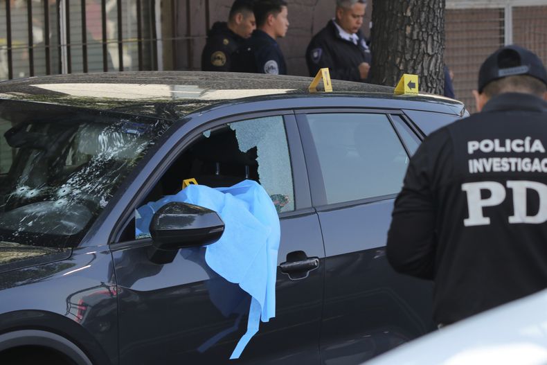 Investigadores de la escena del crimen trabajan en el lugar donde la secretaria personal y un asesor de la alcaldesa de la Ciudad de México fueron asesinados por hombres armados en una motocicleta, en la Ciudad de México, el martes 20 de mayo de 2025. (AP Foto/Tristán Velázquez)