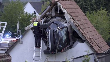 Un policía revisa un automóvil atascado en un granero después de un accidente en Bohmte, Alemania, el domingo 20 de julio de 2025. (Torben Kipp/Nordwestmedia-TV/dpa vía AP)