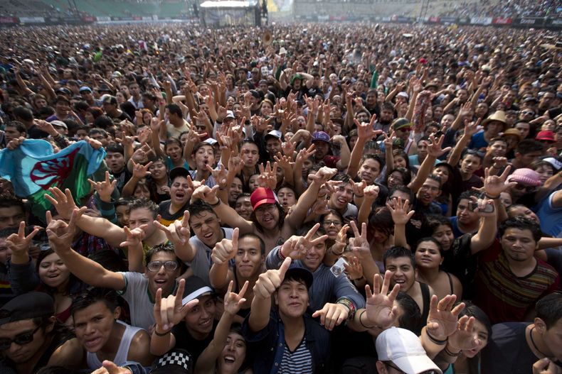 ARCHIVO - Admiradores de Emir Kusturica vitorean mientras toca su guitarra en la 15ta edición del festival Vive Latino en la Ciudad de México, el 29 de marzo de 2014. (Foto AP/Eduardo Verdugo, archivo)