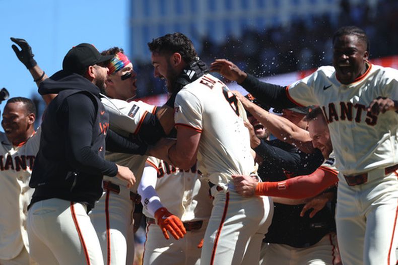 Bryce Eldridge, centro, de los Gigantes de San Francisco, celebra con sus compañeros de equipo después de batear un grand slam para la victoria de su equipo durante la novena entrada del juego de béisbol de Grandes Ligas ante los Nacionales de Washington, el miércoles 10 de junio de 2026, en San Francisco. (AP Foto/Jed Jacobsohn)