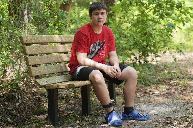 Cayden Gillespie se sienta en la banca de un parque local el sábado 26 de abril de 2025, en Gainesville, Florida. Gillespie pasó meses en detención juvenil tras declararse culpable de dos delitos graves. Mientras estaba en custodia, el estado de Florida le proporcionó educación en línea, en lugar de clases presenciales que, según alumnos, padres y personal, ha sido un desastre. (AP Foto/Marta Lavandier)