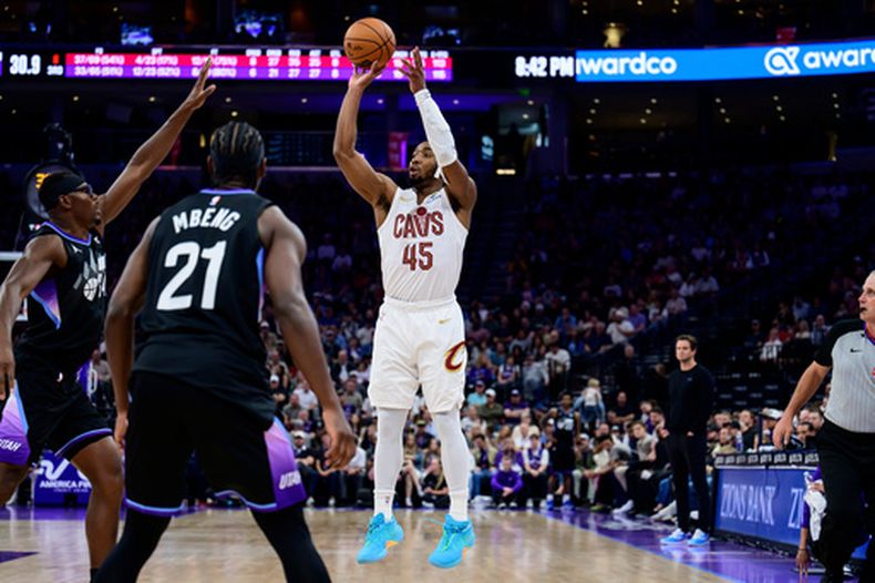 Donovan Mitchell (45), guardia de los Cavaliers de Cleveland, realiza un tiro sobre Oscar Tshiebwe, centro de el Jazz de Utah, a la izquierda, durante la segunda mitad de un juego de baloncesto de la NBA, el lunes 30 de marzo de 2026, en Salt Lake City. (Foto AP/Tyler Tate)