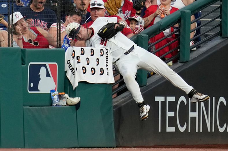 Cooper Ingle, jardinero izquierdo de los Guardianes de Cleveland, cuelga de la barda del jardín después de atrapar una pelota de foul de Drew Romo, de los Medias Blancas de Chicago, en la sexta entrada del juego de béisbol de Grandes Ligas, el sábado 4 de julio de 2026, en Cleveland. (AP Foto/Sue Ogrocki)