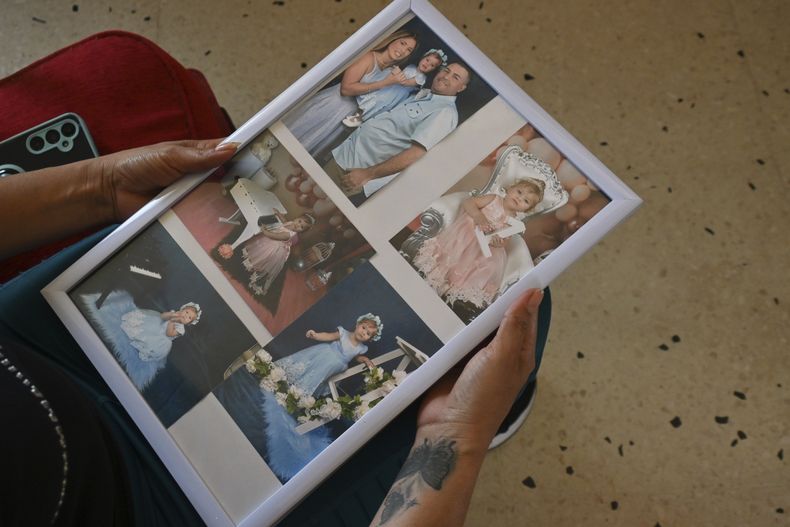 Heidy Sánchez, quien fue deportada de Estados Unidos a Cuba, sostiene fotos de su hija y su esposo, ciudadano estadounidense, en La Habana, el martes 6 de mayo de 2025. (AP Foto/Jorge Luis Baños)