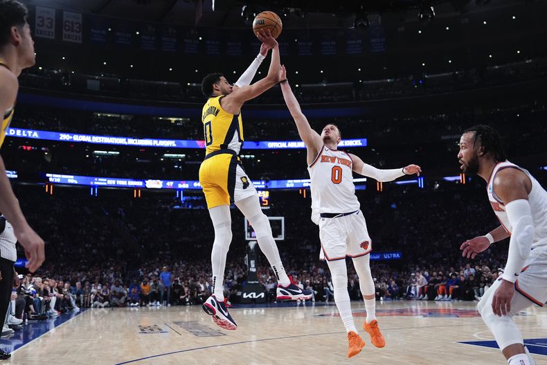 Donte DiVincenzo (0), de los Knicks de Nueva York, marca a Tyrese Haliburton (0), de los Pacers de Indiana, mientras éste toma un tiro durante la primera mitad del Juego 7 de la serie de postemporada de segunda ronda, el domingo 19 de mayo de 2024, en Nueva York. (AP Photo/Julia Nikhinson)