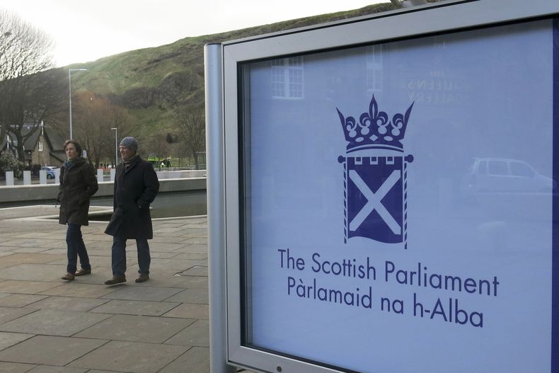 Personas caminan junto al Parlamento escocés en Edimburgo, el 16 de marzo de 2014. (AP Foto/Jill Lawless, Archivo)